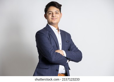 Portrait of a confident young indian teenager boy wearing suit standing with his arms cross, isolated on white studio background. - Powered by Shutterstock