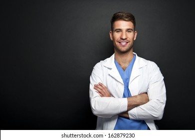 Portrait Of Confident Young Medical Doctor On Dark Background