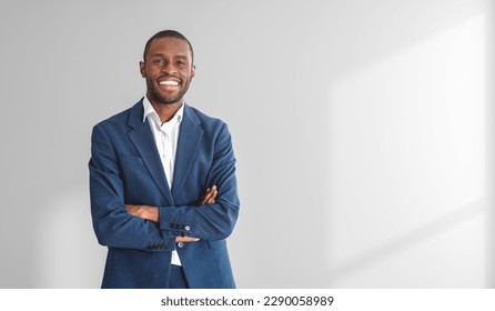 Portrait of confident young smiling African American businessman standing with crossed arms over white background. Mock up - Powered by Shutterstock