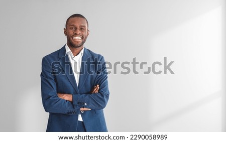 Similar – Image, Stock Photo Young black businessman in suit standing on stairs