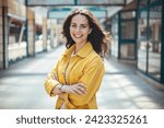 Portrait of a confident young woman standing at the city. Beautiful female in casuals looking at camera. Happy young woman on street.  Latin stylish girl smiling while standing on street.