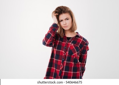 Portrait Of A Confused Pretty Girl In Plaid Shirt Looking At Camera Isolated On A White Background