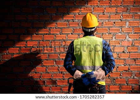 Portrait Of Construction Worker On Building Site ,Close up of industrial bricklayer installing bricks on construction site