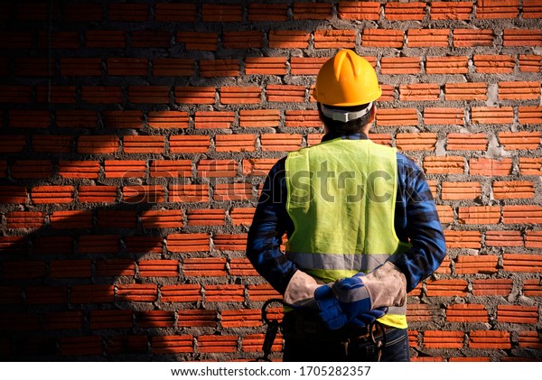 Portrait Of Construction Worker On Building Site\
,Close up of industrial bricklayer installing bricks on\
construction site