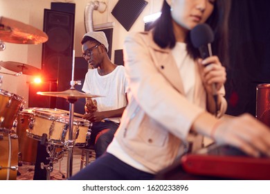 Portrait Of Contemporary Band Writing Music In Recording Studio Focus On Young African Man Playing Drums, Copy Space