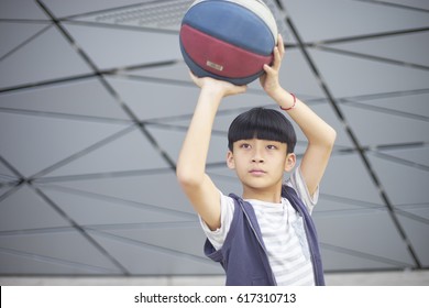 Portrait Of Cool Asian Kid Holding Basketball Aiming & Shooting