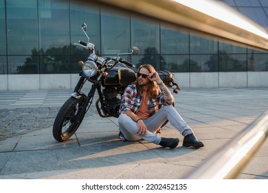 Portrait Of Cool Guy Biker With Sunglasses Sitting On Asphalt.