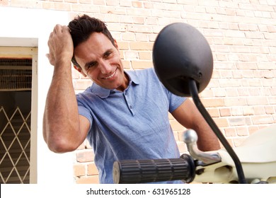 Portrait Of Cool Older Man Sitting On Scooter Looking In Mirror With Hand In Hair