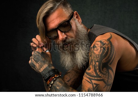 Portrait of a cool, tatooed biker with sunglasses