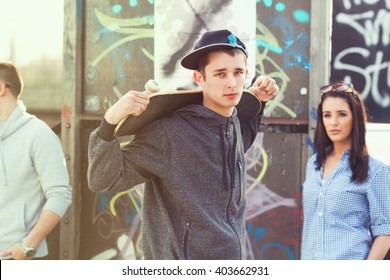 Portrait of cool  teenage boy with a skateboard on his shoulder - Powered by Shutterstock