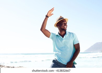 Portrait of cool young african man dancing at the beach on summer day