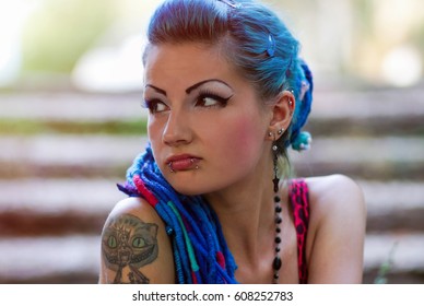 Portrait Of Cool Young Tattooed Punk Chick With Long Dyed Braided Hair.Stylish Teenager Girl With Tatoo On Shoulder Posing Outdoor.Attractive Street Fashion Model