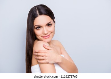 Portrait with copy space empty place for advertisement product enjoying body skin after exfoliation wrapped in white towel touching shoulder isolated on grey background. Wellness wellbeing concept