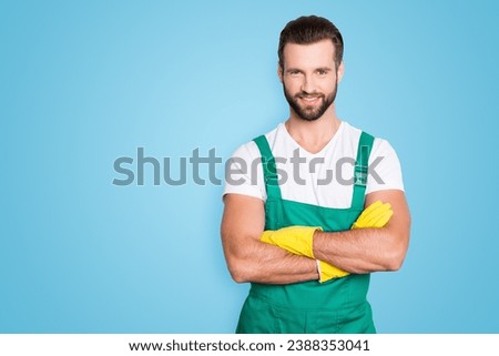 Portrait with copy space, empty place for advertisement, product of cheerful joyful man with stubble in uniform having arms crossed, looking at camera, isolated on grey background