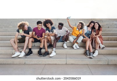 Portrait with copy space of group of mixed race people with smart phones. Excited students using their technological devices. Concept of young enterprising, selfie, millennial. - Shutterstock ID 2043586019
