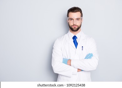 Portrait with copyspace, empty place of stylish handsome scientist with stubble in white outfit with tie having his arms crossed looking at camera isolated on grey background