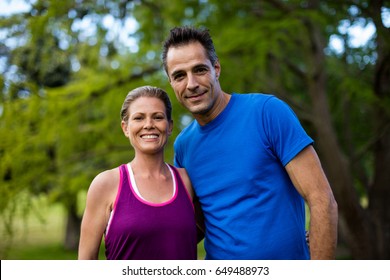 Portrait of couple with arms around in park - Shutterstock ID 649488973
