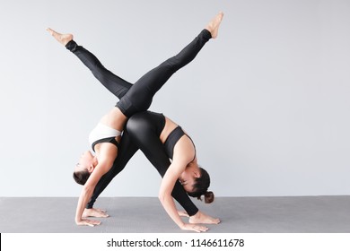 Portrait of couple beautiful young women wearing sportswear practicing yoga in studio,natural light.Concept : Partner yoga poses for beginner.
Triangle forward bend and handstand pose. - Powered by Shutterstock