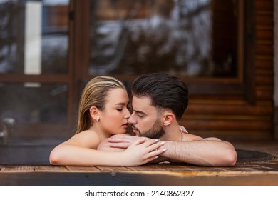 portrait of a couple kissing in a tub of water