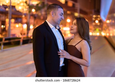 Portrait Of Couple Looking Each Other Outdoors At Night In The City At Bangkok Thailand