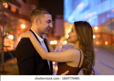 Portrait Of Couple Looking Each Other Outdoors At Night In The City At Bangkok Thailand