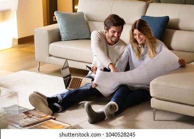 Portrait Of A Couple In Love Who Is Planning New Home And Furniture. The Two Couples Smile And Are Happy With The Futuristic Project Together. Concept Of: Future, Family, Design And Projects.