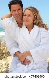 Portrait of couple on dunes in toweling robes
