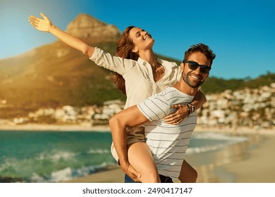 Portrait, couple and piggyback on beach for love, commitment and bonding on summer vacation for honeymoon. Man, woman and freedom by ocean for romantic holiday, affection and weekend with embrace. - Powered by Shutterstock