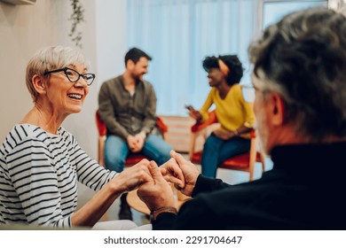 Portrait of a couple of senior people holding hands while participating in group therapy session. Sharing problems, telling stories during psychological rehab session. Copy space. - Powered by Shutterstock