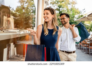 Portrait of a couple with shopping bags in the city. People sale love and happiness concept.