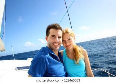 Portrait Of Couple Sitting On The Top Of Sailing Boat