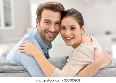 Porträt von Ehepaaren, die zu Hause auf dem Sofa sitzen