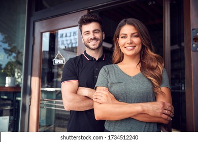 Portrait Of Couple Starting New Coffee Shop Or Restaurant Business Standing In Doorway - Shutterstock ID 1734512240