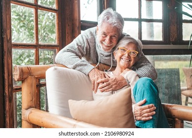 Portrait of couple of two happy and healthy seniors old people smiling and looking at the camera. Close up of mature grandparents enjoying and having fun together at home indoor.