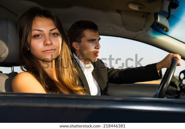 Portrait of a\
couple of young people in the\
car