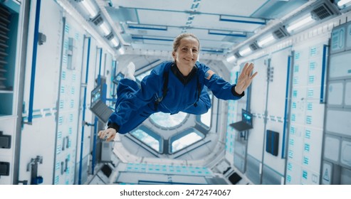 Portrait of a Courageous Caucasian Female Astronaut on Board a Spacecraft, Floating in Zero Gravity and Smiling At The Camera, Waving. Deep Space Travel, Solar System Exploration and Colonization. - Powered by Shutterstock