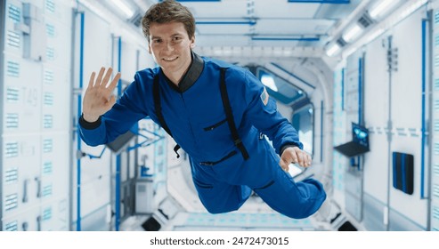 Portrait of a Courageous Caucasian Male Astronaut on Board a Spacecraft, Floating in Zero Gravity and Smiling At The Camera, Waving. Space Travel, Solar System Exploration and Colonization Concept - Powered by Shutterstock