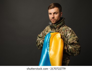 Portrait Of A Courageous Ukrainian Military Man Holding The Flag Of Ukraine, Freedom Concept