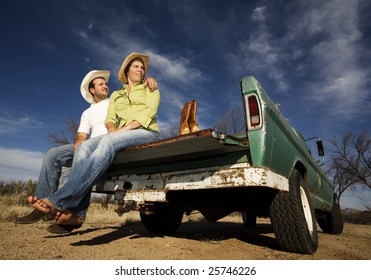 Portrait Of Cowboy And Woman On Pickup Truck Bed