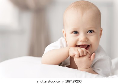 Portrait of a crawling baby on the bed in her room - Shutterstock ID 189429203