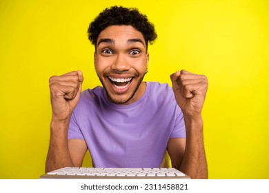Portrait of crazy delighted guy raise fists celebrate achievement keyboard isolated on yellow color background - Shutterstock ID 2311458821