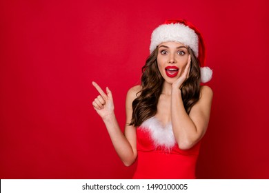 Portrait of crazy lady with long curly hairstyle pointing at copy space follow ads scream wow omg wearing stylish dress skirt isolated over red background