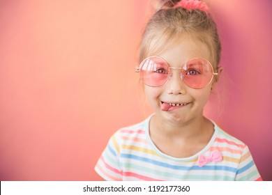 Portrait Of Crazy Little Teen Girl Shows Tongue In Pink Sunglasses