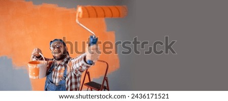 Portrait of Crazy male painter painting wall in new home. Renovation, redecoration and repair concept. Banner. Copy space [[stock_photo]] © 