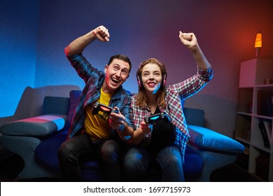 Portrait von verrückten spielerischen Paar, Gamer genießen Spielen Video-Spiele drinnen sitzen auf dem Sofa, halten Console Gamepad in Händen. Zurück zu Hause, haben ein tolles Wochenende