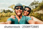 Portrait crazy smiley young happy caucasian couple take smartphone selfie while having fun driving scooter on tropical road trip in southeast asia. Couple in love having fun travel in asia