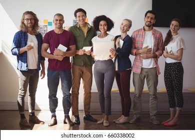 Portrait of creative business team standing together at office - Shutterstock ID 660338002
