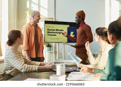 Portrait Of Creative Team Meeting In Office With Focus On Black Man Giving Marketing Presentation