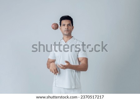Portrait of Cricketer holding cricket boll in hand and looking towards the camera in aggression , Cricket concept shoot