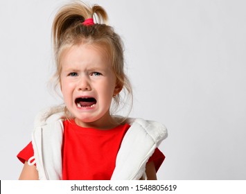 Portrait of crying, yelling, abused helpless kid girl in red t-shirt after family conflict. Got lost. In difficulty. Family conflict, violence, injustice, unfairness
